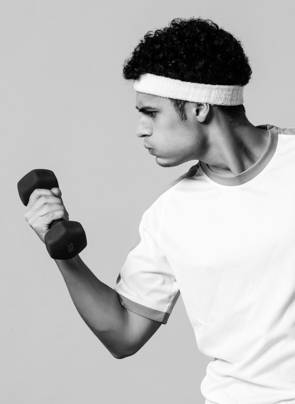 male holding a dumbbell black and white